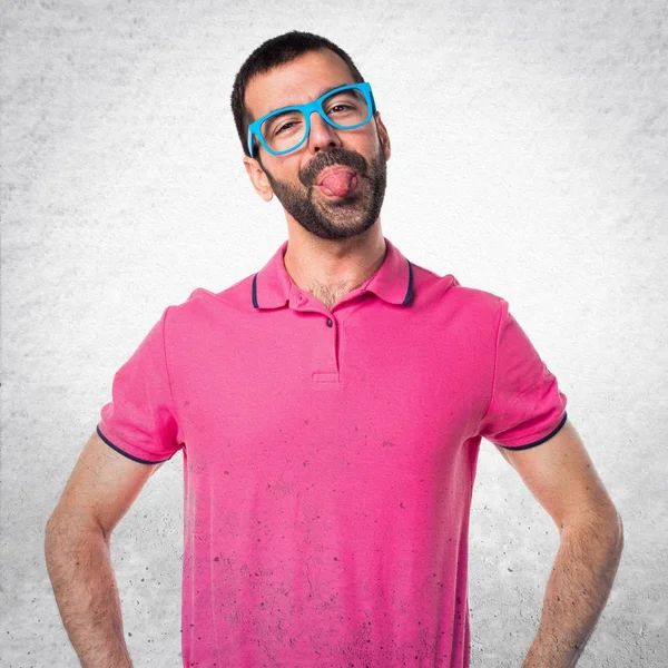 Homme avec des vêtements colorés faisant une blague sur fond texturé gris — Photo