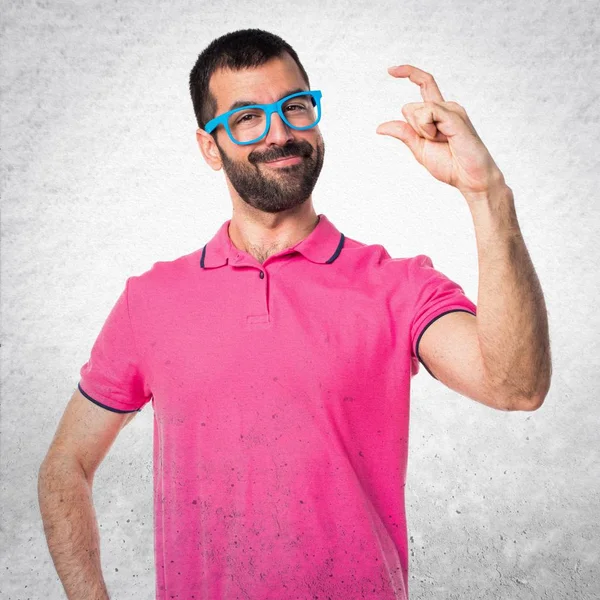 Homem com roupas coloridas segurando algo no bac texturizado cinza — Fotografia de Stock