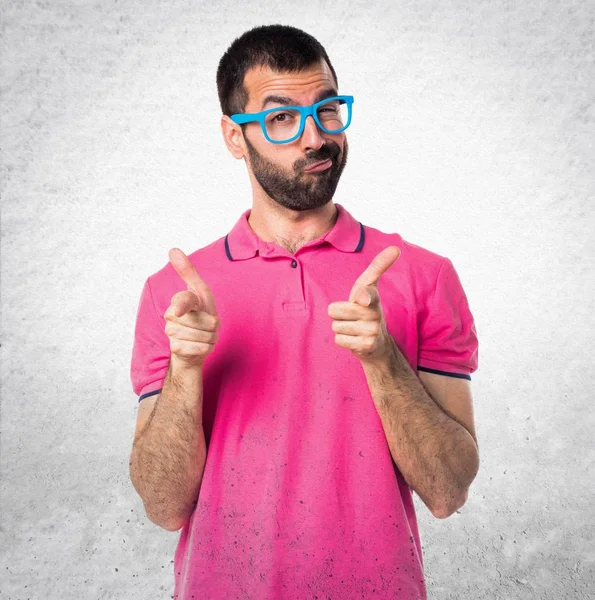 Renkli giysiler dokulu gri cephesinde işaret eden adamla — Stok fotoğraf