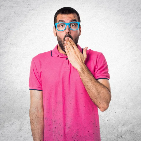 Άνθρωπος με πολύχρωμα ρούχα κάνει έκπληξη χειρονομία για την υφή του γκρι — Φωτογραφία Αρχείου