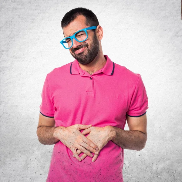 Ο άνθρωπος σε πολύχρωμα ρούχα με στομαχόπονο σε γκρι σαγρέ έκφραση — Φωτογραφία Αρχείου