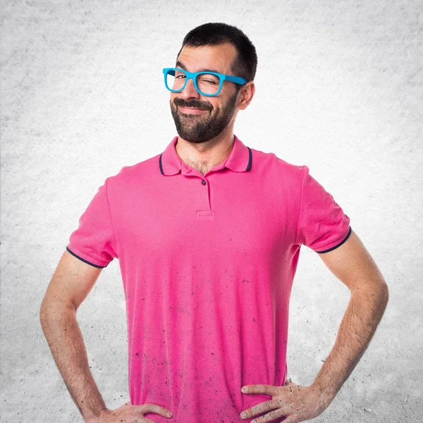 Mannen med färgglada kläder winking på grå texturerat bakgrund — Stockfoto