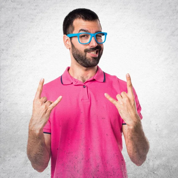 Άνθρωπος με πολύχρωμα ρούχα κάνοντας χειρονομία κέρατο στο γκρι σαγρέ β — Φωτογραφία Αρχείου