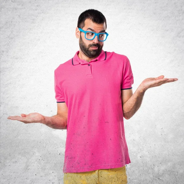 Homme avec des vêtements colorés faisant un geste sans importance sur tex gris — Photo