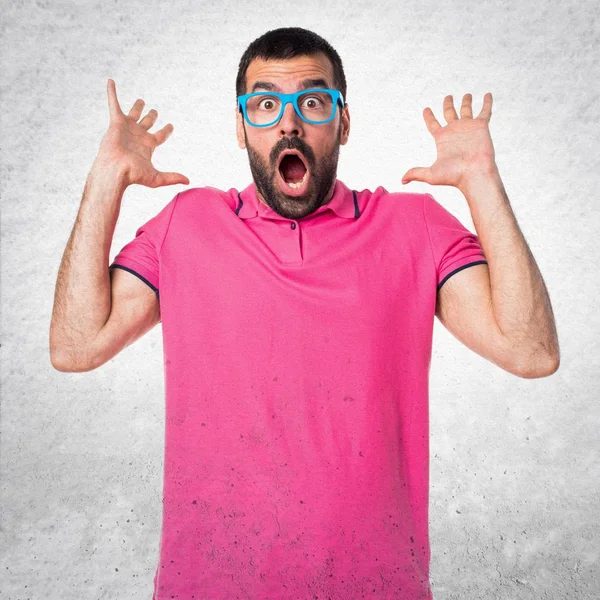 Hombre con ropa colorida haciendo gesto sorpresa en textura gris —  Fotos de Stock