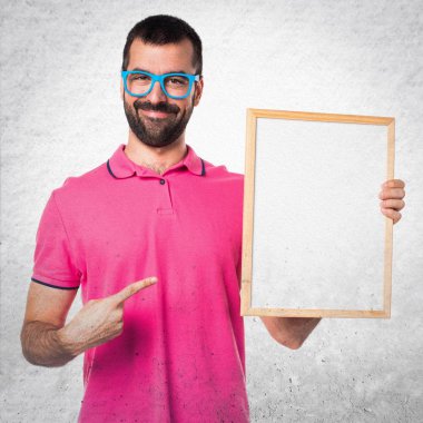 Renkli elbise gri textu üzerinde boş bir afişini tutan adamla