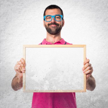 Renkli elbise gri textu üzerinde boş bir afişini tutan adamla