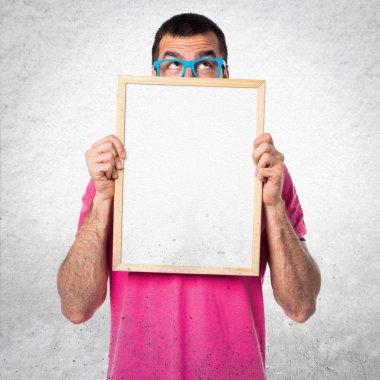 Renkli elbise gri textu üzerinde boş bir afişini tutan adamla