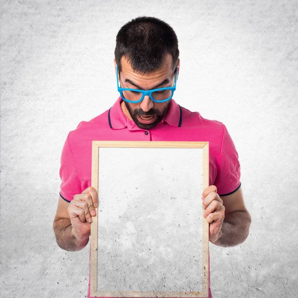 Muž s barevné oblečení drží prázdné cedulky na šedé textu — Stock fotografie