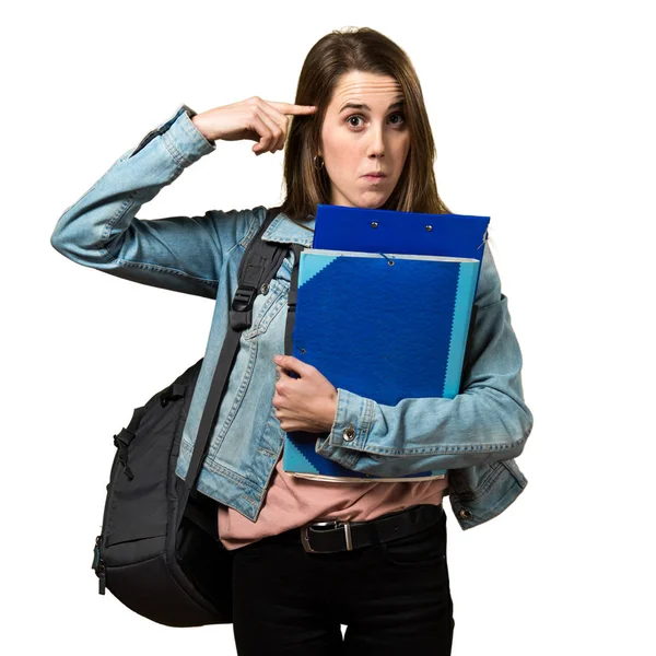 Adolescente estudiante chica sosteniendo libros y haciendo loco gesto —  Fotos de Stock