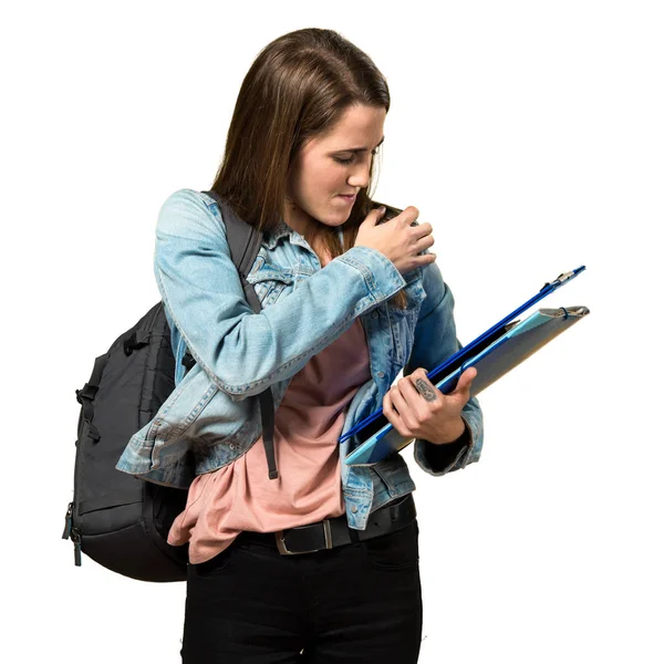 Adolescente estudiante chica sosteniendo libros y con hombro dolor —  Fotos de Stock