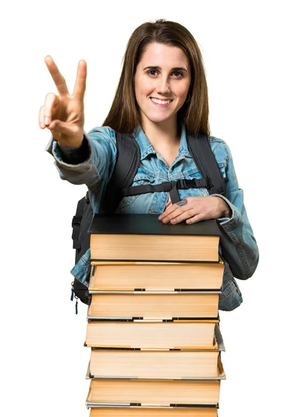 Adolescente menina estudante com um monte de livros e contando dois — Fotografia de Stock