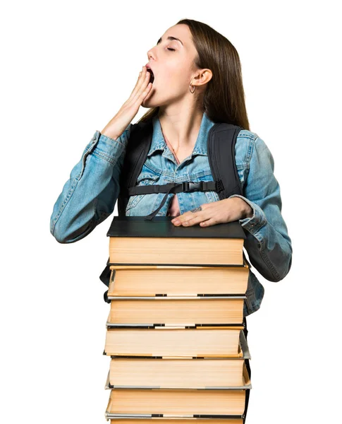 Adolescente menina estudante com um monte de livros e bocejo — Fotografia de Stock