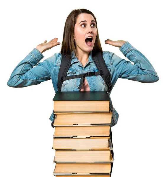 Tiener student meisje met een heleboel boeken verrassing gebaar maken — Stockfoto