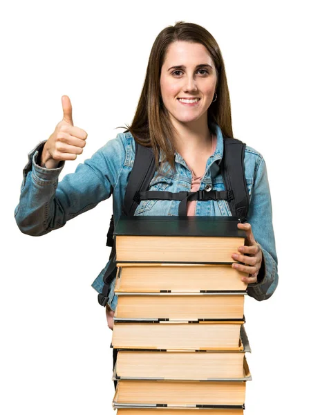 Девочка-подросток с большим количеством книг и большим пальцем вверх — стоковое фото