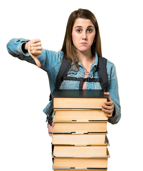 Adolescente estudiante chica con un montón de libros y haciendo mala señal — Foto de Stock