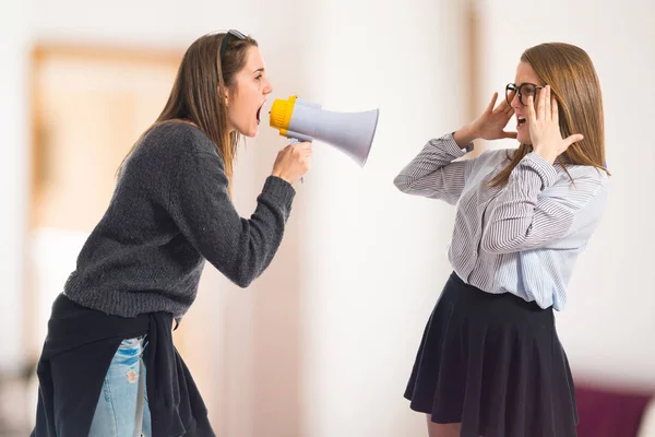 Девушка кричит на сестру через мегафон — стоковое фото
