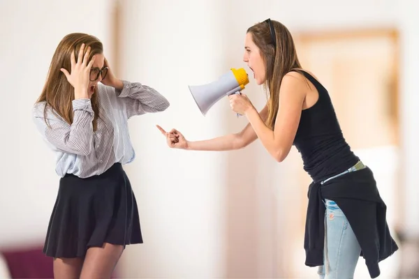 Jente som skriker til sin søster med megafon – stockfoto