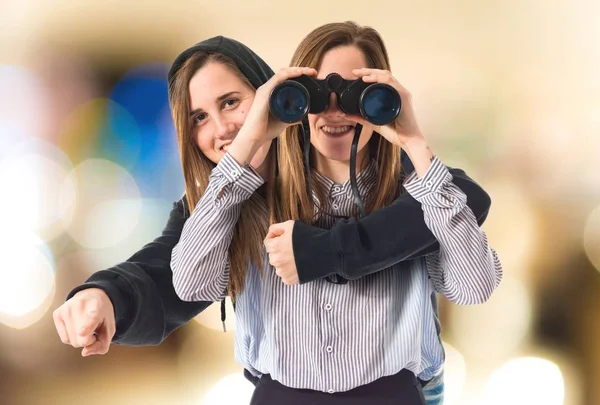 Twin sisters with binoculars — Stock Photo, Image