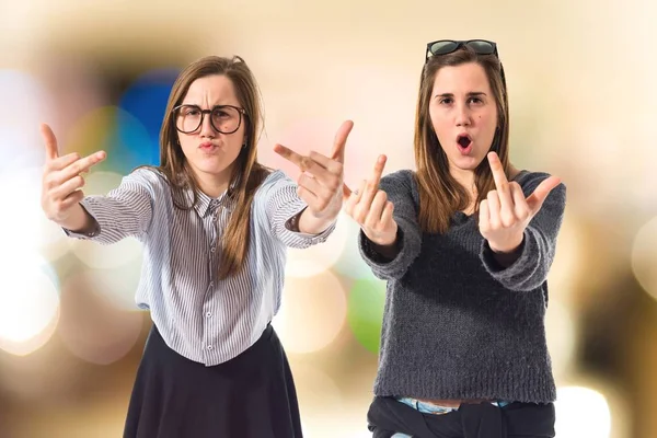 Irmãs gêmeas fazendo gesto chifre — Fotografia de Stock