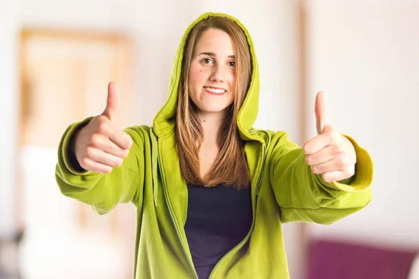 Chica bastante joven con pulgares arriba sobre fondo blanco — Foto de Stock