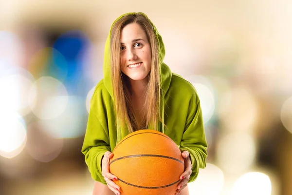 Menina loira jogando basquete sobre fundo branco — Fotografia de Stock