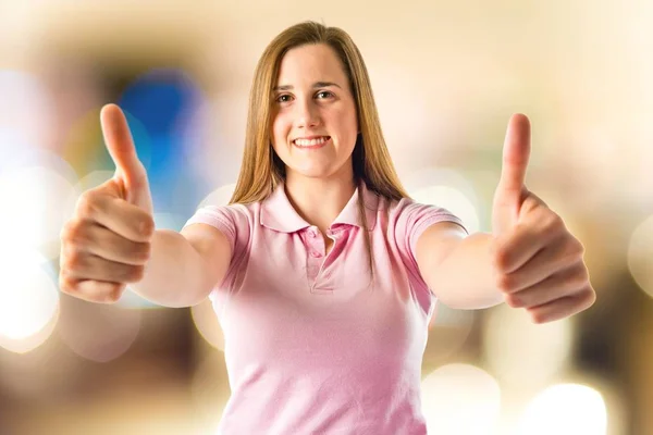Young girl making Ok sign over white background