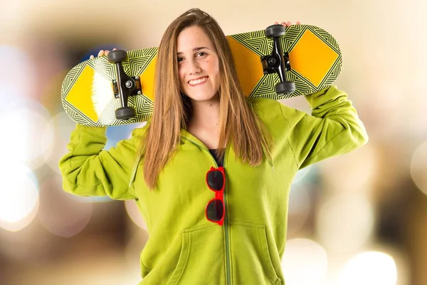 Menina loira com skate sobre fundo branco — Fotografia de Stock