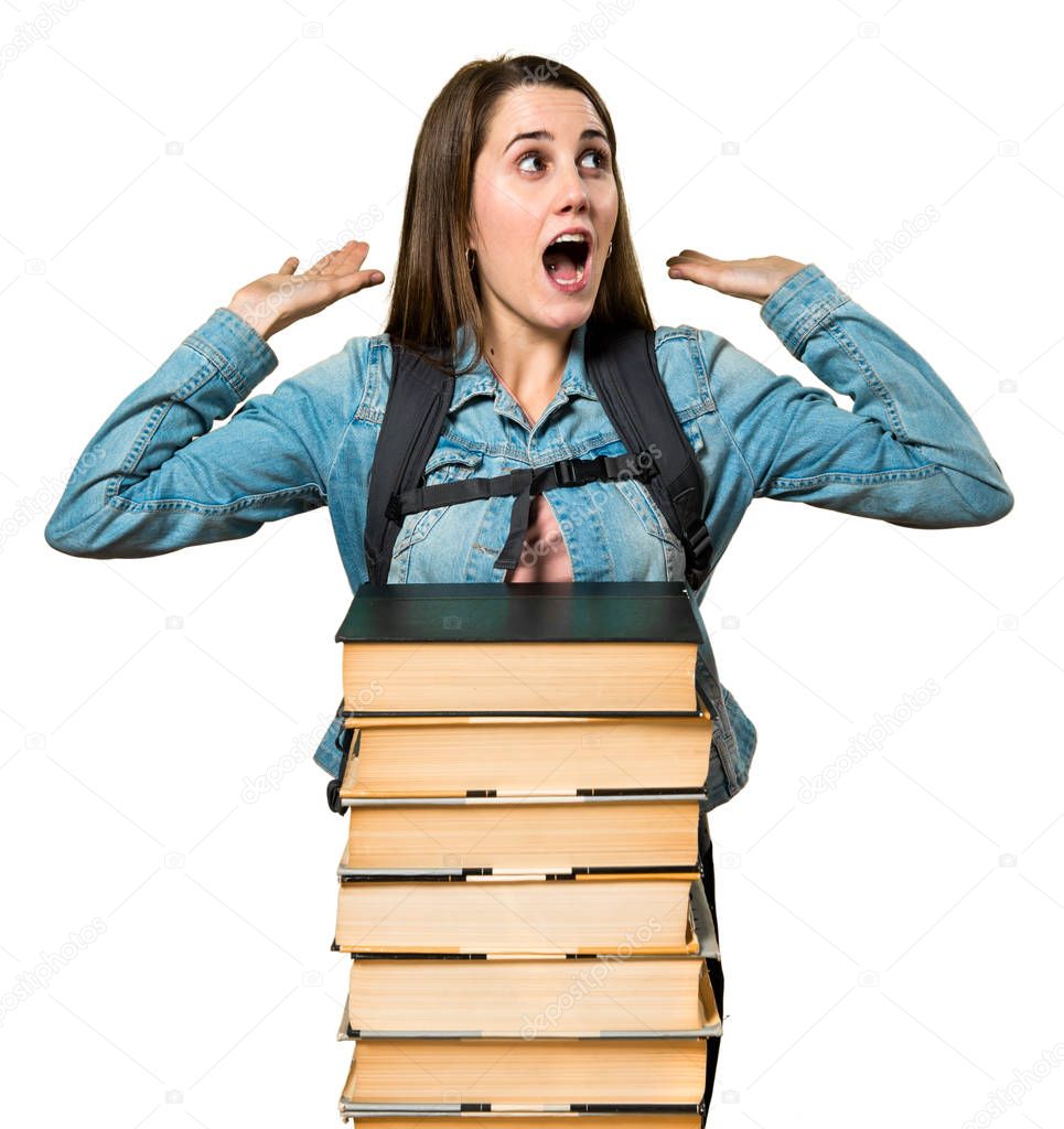 Teen student girl with a lot of books making surprise gesture