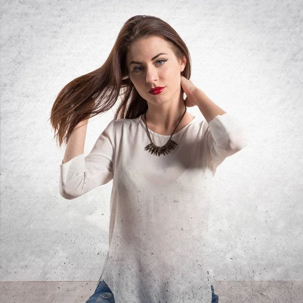 Young pretty model woman posing in studio on textured grey backg — Stock Photo, Image