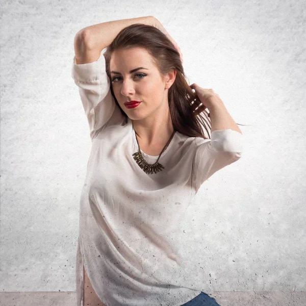 Giovane bella donna modello in posa in studio su strutturato dorso grigio — Foto Stock