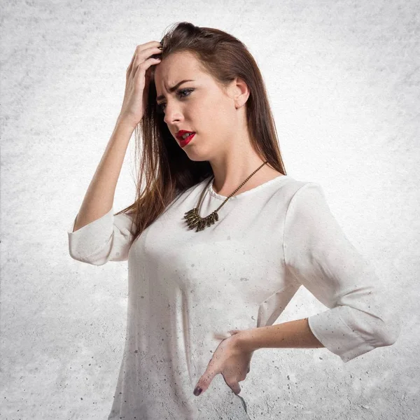 Dokulu gri arka plan üzerinde ağrısı olan genç ve güzel kız