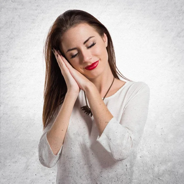 Pretty young girl making sleep gesture on textured grey backgrou — Stock Photo, Image