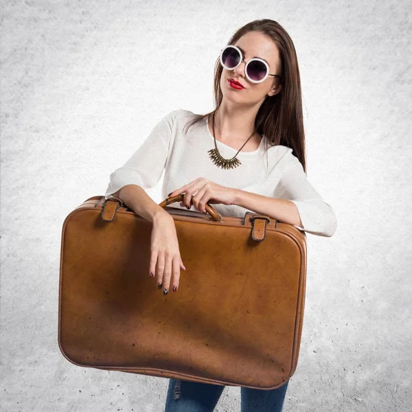 Chica bastante joven con gafas de sol sosteniendo un maletín vintage en — Foto de Stock
