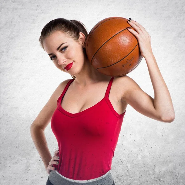 Pretty sport woman playing basketball on textured grey backgroun — Stock Photo, Image