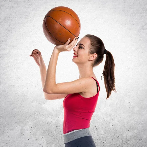 Pretty sport woman playing basketball on textured grey backgroun — Stock Photo, Image