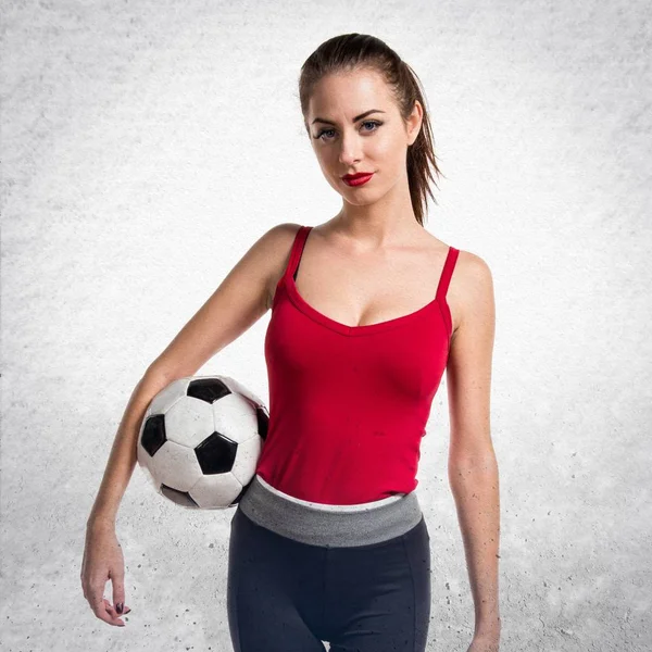 Bir futbol topu dokulu gri backgr üzerinde tutan güzel spor kadın — Stok fotoğraf