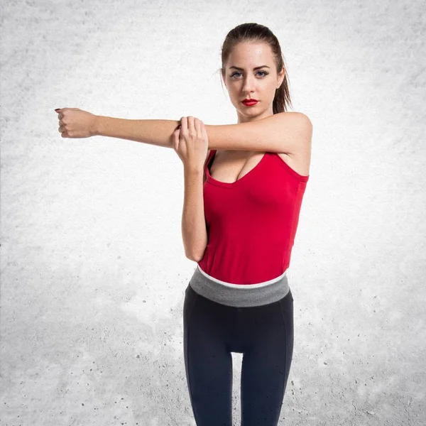 Vackra sport kvinna stretching på texturerat grå bakgrund — Stockfoto