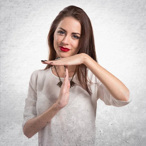 Pretty genç kız zaman aşımı jest yapma dokulu gri backg