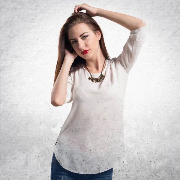 Young pretty model woman posing in studio on textured grey backg