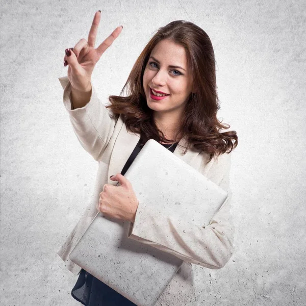 Ganska ung affärskvinna med laptop och göra seger gestu — Stockfoto
