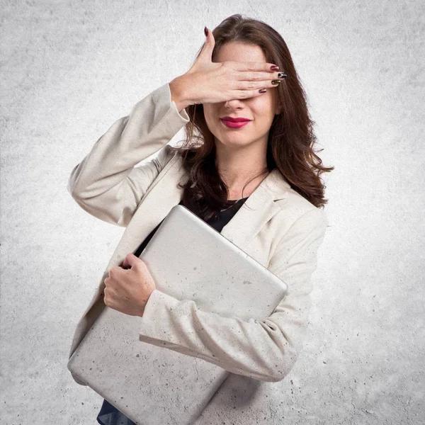 Hübsche junge Geschäftsfrau mit Laptop und bedeckt seine Augen auf — Stockfoto