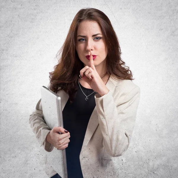 Pretty young business woman with laptop making silence gesture o — Stock Photo, Image