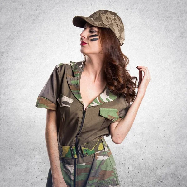 Vacker ung militär flicka på texturerat grå bakgrund — Stockfoto