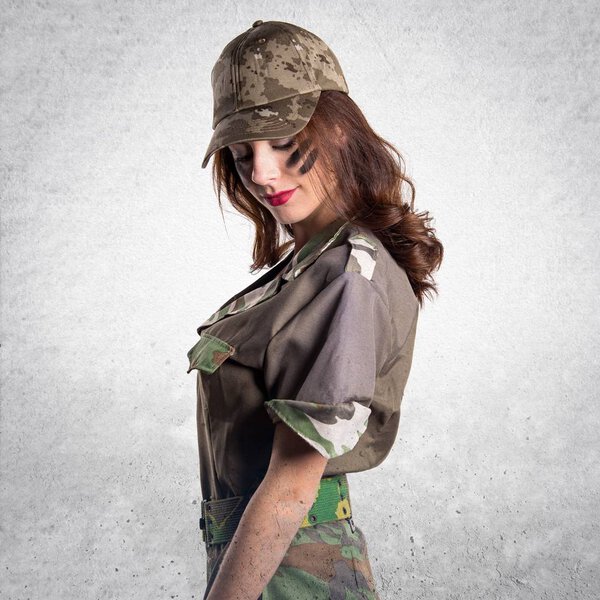 Beautiful young military girl on textured grey background