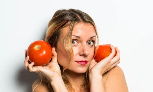 Beautiful blonde woman holding tomatoes — Stock Photo, Image