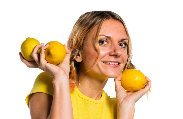 Schöne blonde Frau hält Zitronen — Stockfoto