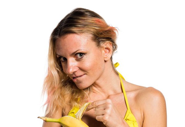 Beautiful blonde woman in bikini holding bananas