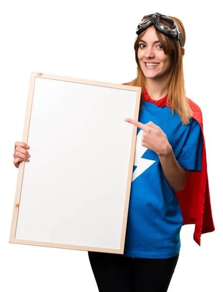 Bastante chica superhéroe sosteniendo un cartel vacío — Foto de Stock