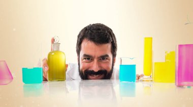 Test tüpleri koyu sarı zemin üzerine arkasına saklanmış bilim adamı